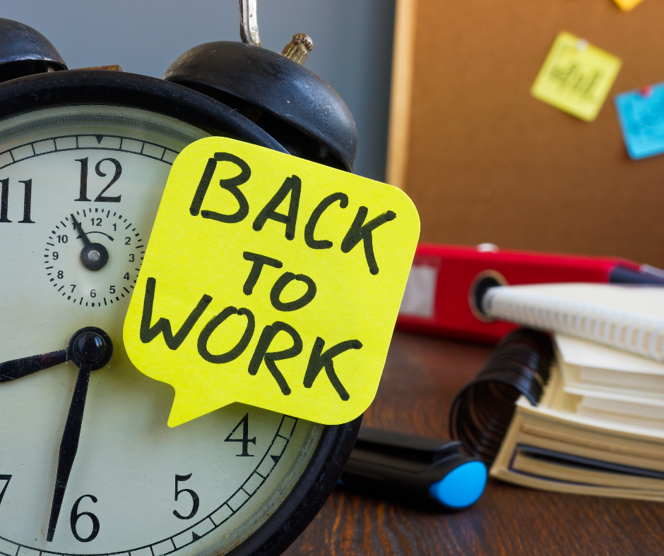 Budzik z karteczką back to work, obrazujący kryzys po urlopie.